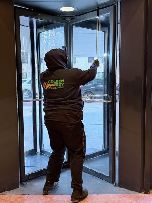 Golden Key Locksmith NYC technician responding to an emergency call at a revolving door entrance in NYC